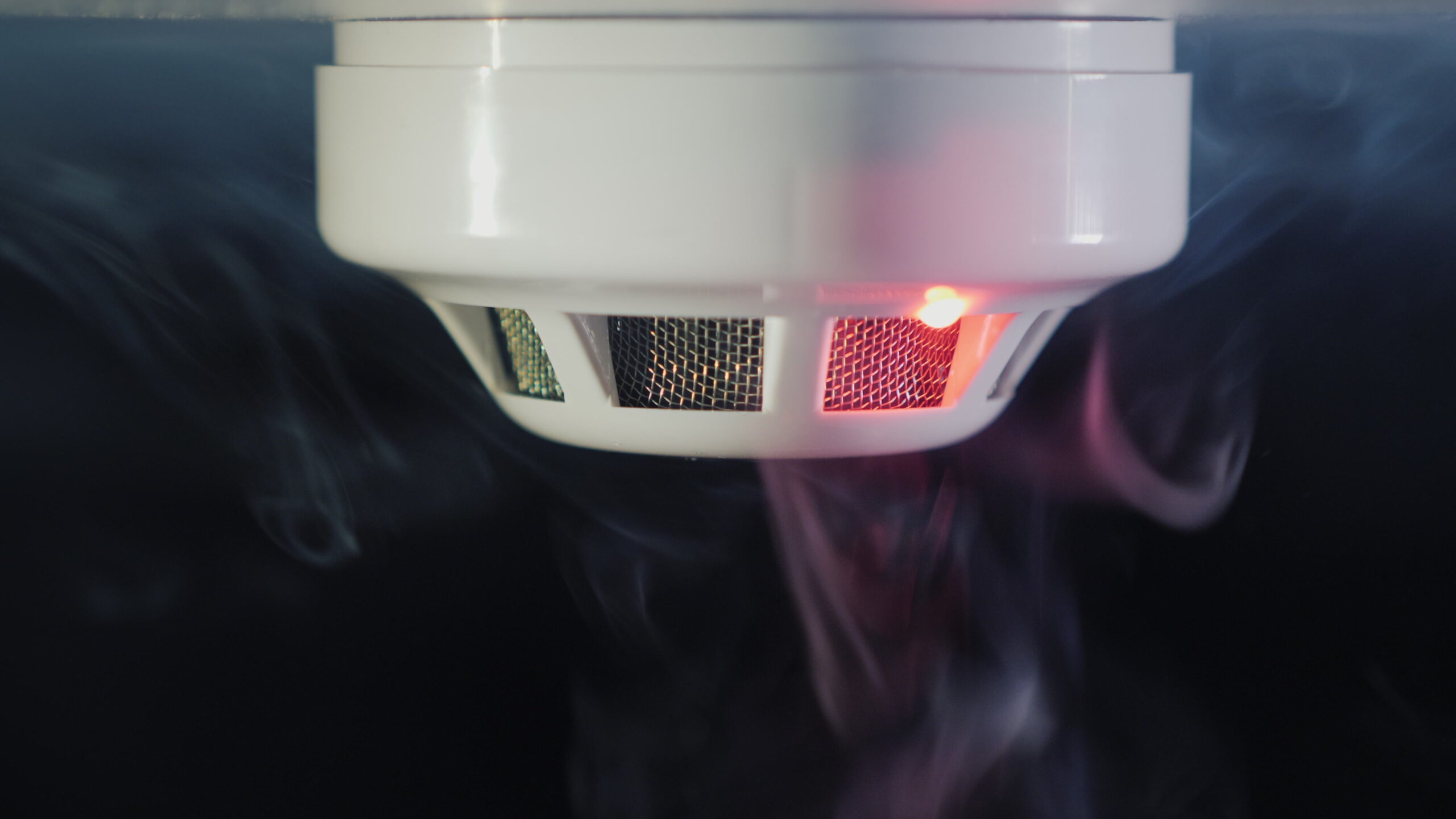 Close-up shot: The smoke detector is triggered by a trickle of dum, the red indicator lights up