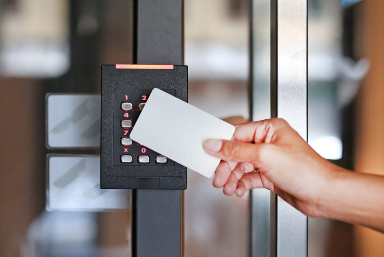 Door access control - young woman holding a key card to lock and unlock door.