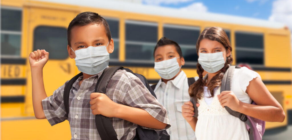Hispanic Students Near School Bus Wearing Face Masks