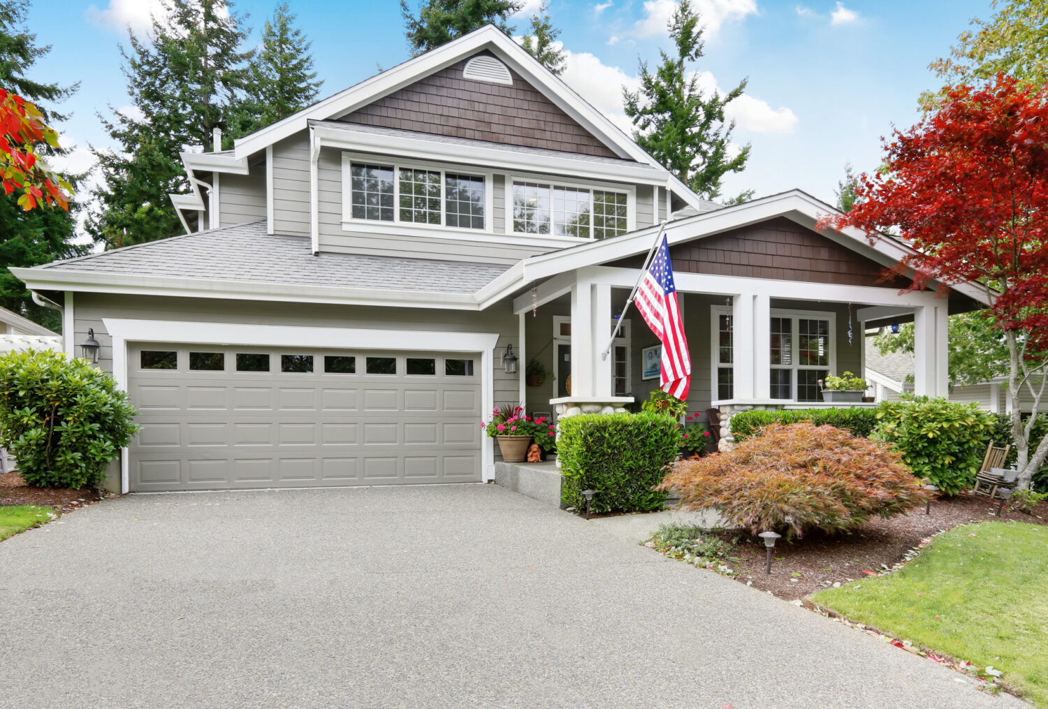 Nice curb appeal of grey house with covered porch and garage