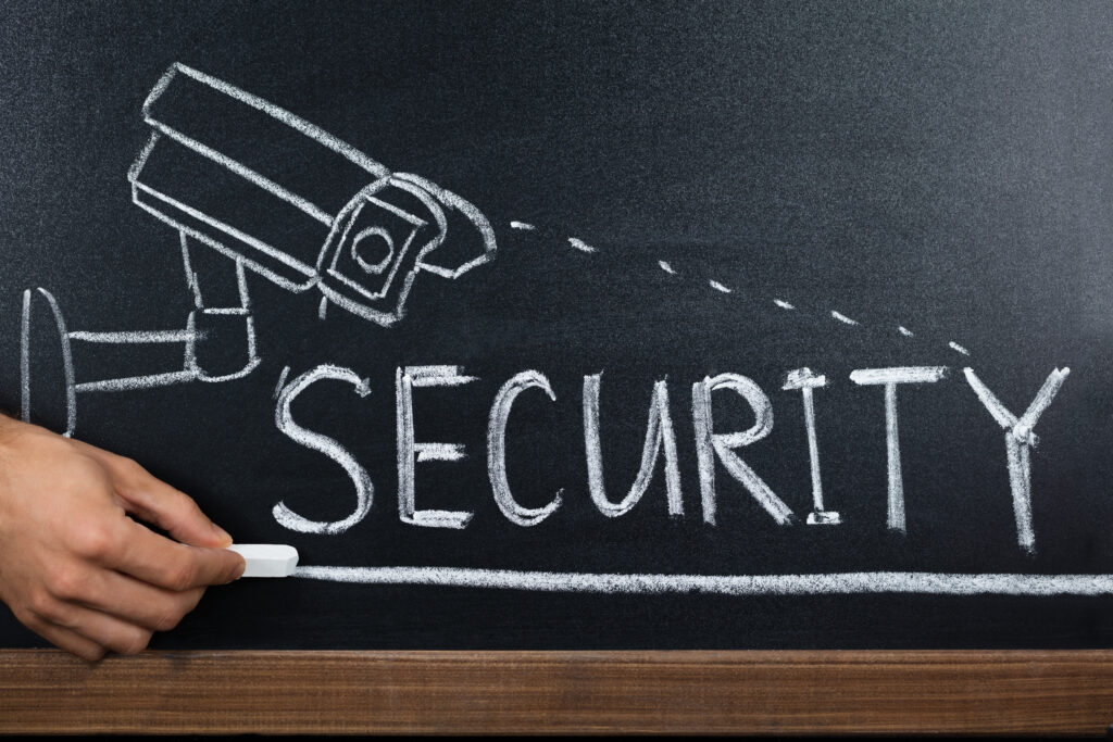 Person Hand Showing Security Concept On Blackboard