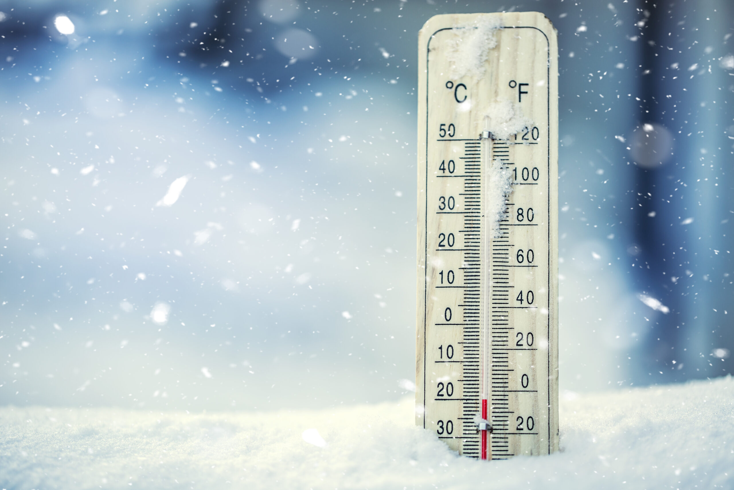 Thermometer on snow shows low temperatures under zero. Low temperatures in degrees Celsius and fahrenheit. Cold winter weather twenty under zero.