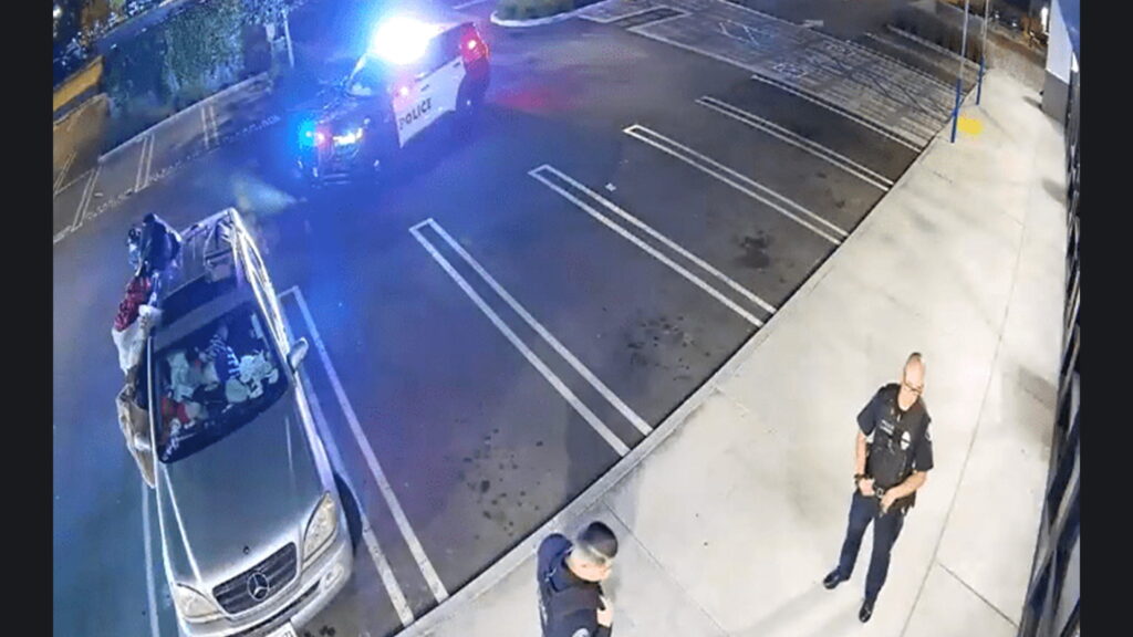 Police vehicle with flashing lights responds to overnight trespasser at Pasadena commercial property monitored by live video surveillance