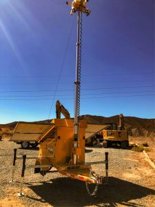 Mobile security trailer with telescoping camera pole and construction excavator at remote Castaic industrial worksite