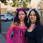 Two attendees in pink and black cat costumes with ears and makeup at Valley Alarm Halloween event 2025