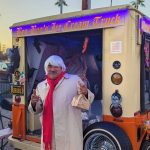 Attendee in white suit costume in front of decorated Boo-Boos Ice Cream Truck at Valley Alarm Trunk-or-Treat San Fernando 2025