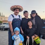 Family in shark costume and Mexican folk costumes at Valley Alarm Trunk-or-Treat San Fernando 2025