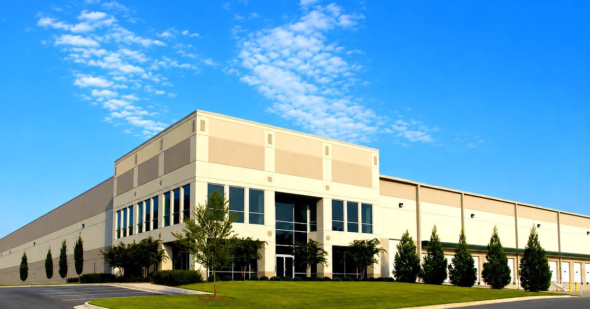Commercial warehouse exterior with security cameras monitoring the facility instead of on-site guards in Los Angeles