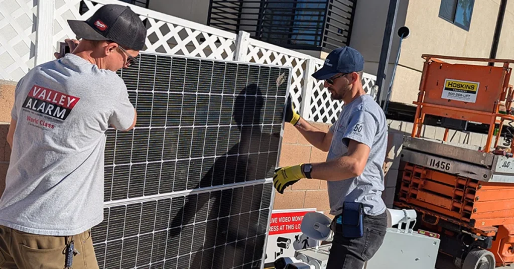 Valley Alarm technicians installing a solar pole-mounted security camera system in Los Angeles