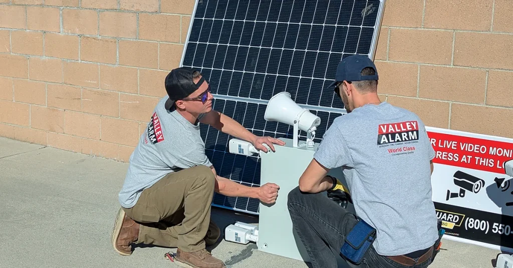 Valley Alarm technicians installing a vertical solar pole security camera kit in Los Angeles