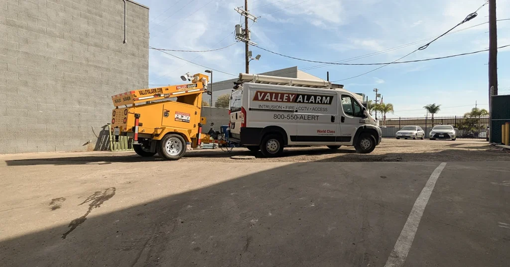 Valley Alarm technician van with a solar mobile surveillance unit at an industrial facility in Los Angeles