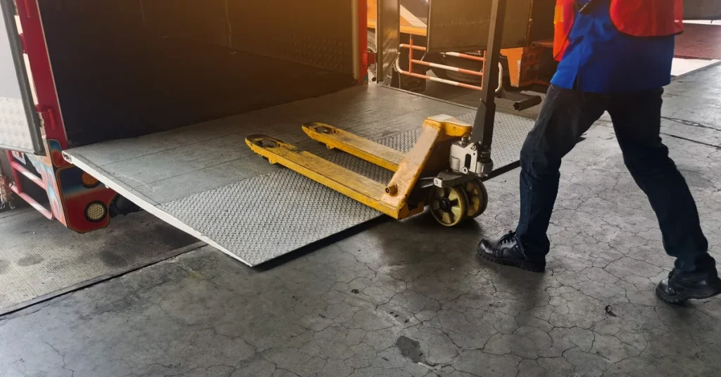 Worker moving a pallet jack at a warehouse loading dock where access control governs entry
